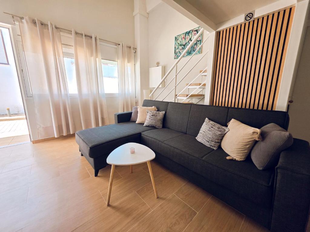 a living room with a black couch and a table at Loft Suites - by Avelink in Spata
