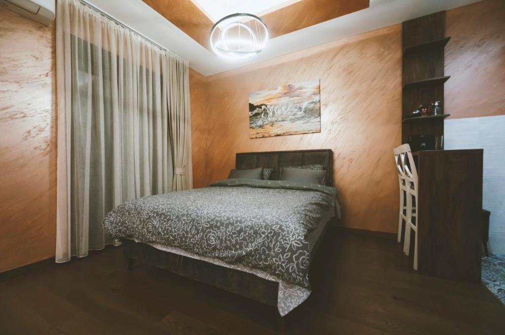 a bedroom with a bed and a table and a window at Green Hills by MI in Podgorica