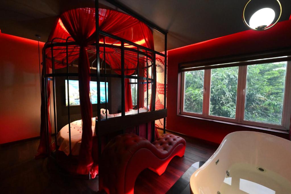 a bedroom with a bed in a room with red lighting at L'amour Hotel in Ho Chi Minh City
