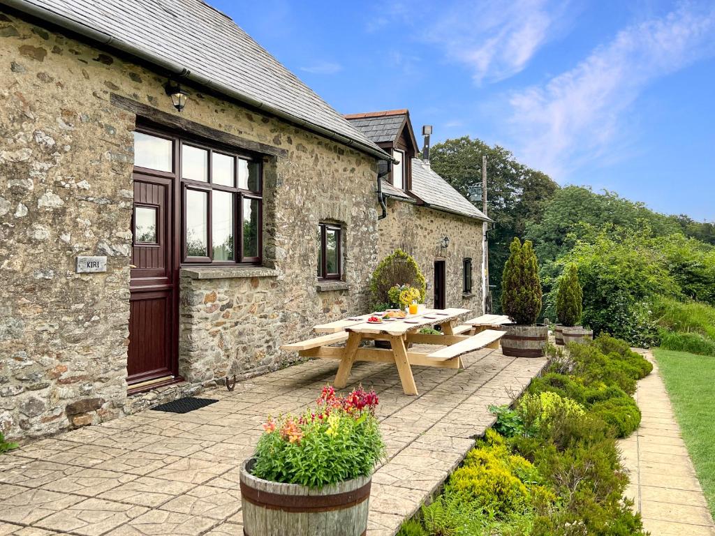 a stone building with a picnic table in front of it at Kiri Cottage Hawkridge in Dulverton