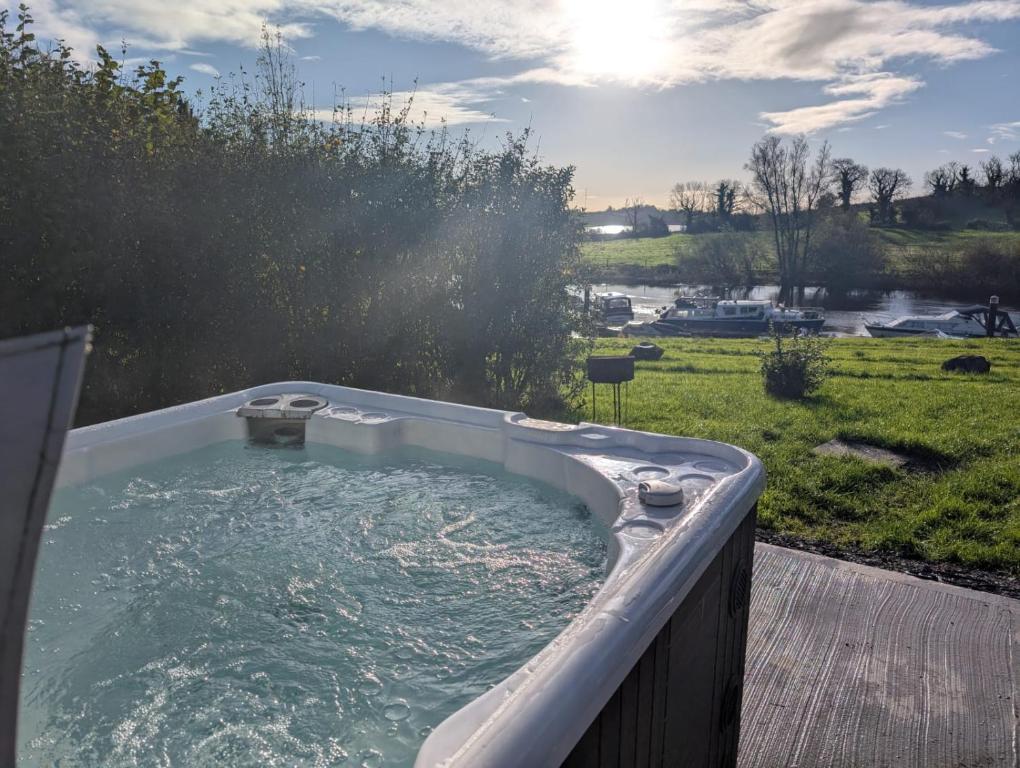 a hot tub on a deck with a view of a yard at Rose Glamping pod in Derrylin