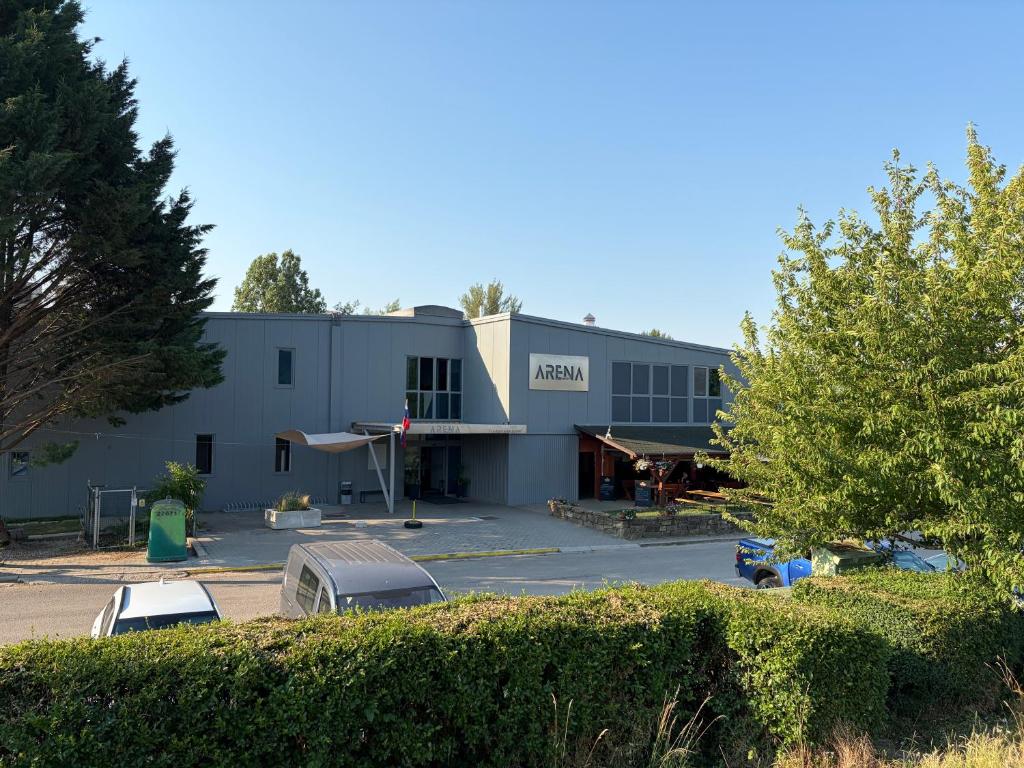 a building with cars parked in a parking lot at Penzion ARENAostrov in Trenčín