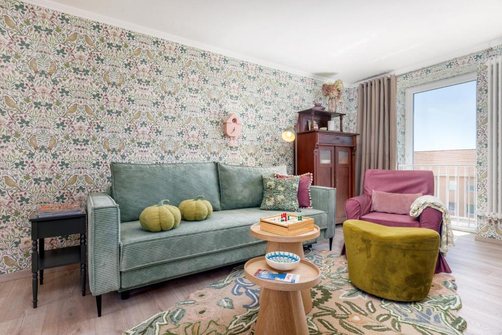 a living room with a green couch and a chair at Ferienwohnung Morgen am Meer in Sassnitz