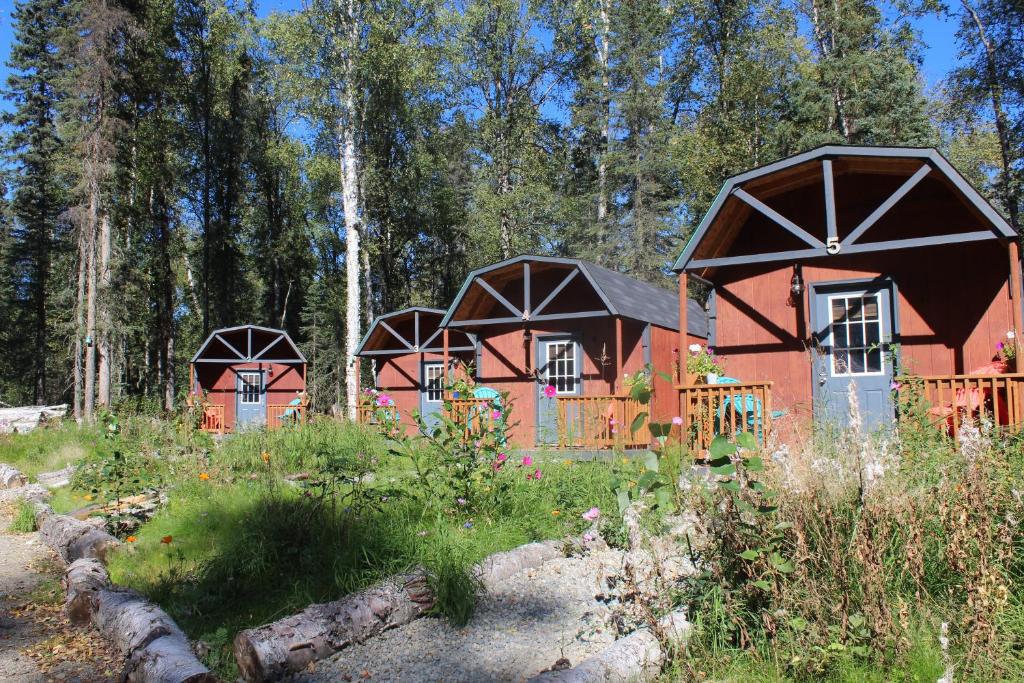 a group of three houses in a forest at DFA Cabin Rentals in Talkeetna