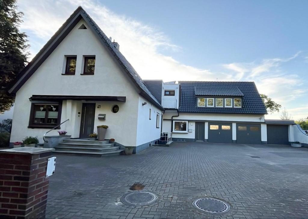 a white house with a driveway in front of it at Sommer Gästehaus in Bremerhaven