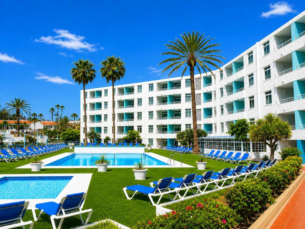 a resort with a pool and chairs and palm trees at Apartamentos Tamaragua in Playa del Ingles