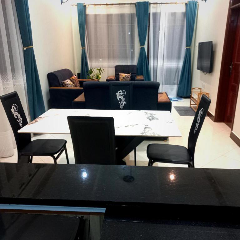 a living room with a table and chairs and a couch at Celesta House in Mbarara