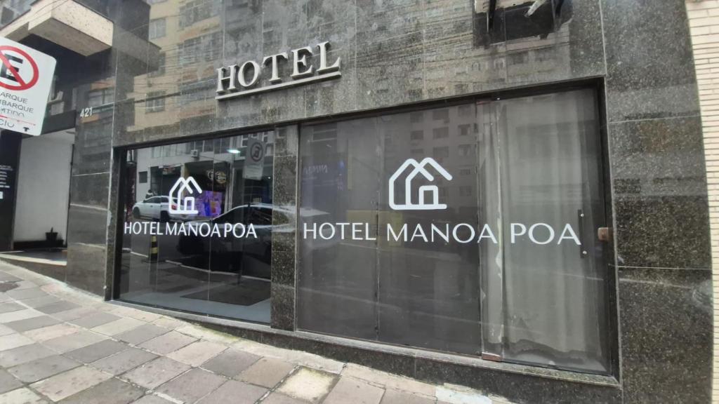 a store window of a hotel in a city at Hotel Manoá Poa - Ambiente acolhedor e humanizado, seu refúgio estratégico no centro de Poa, próx a UFRGS, rodoviária e a Santa Casa in Porto Alegre
