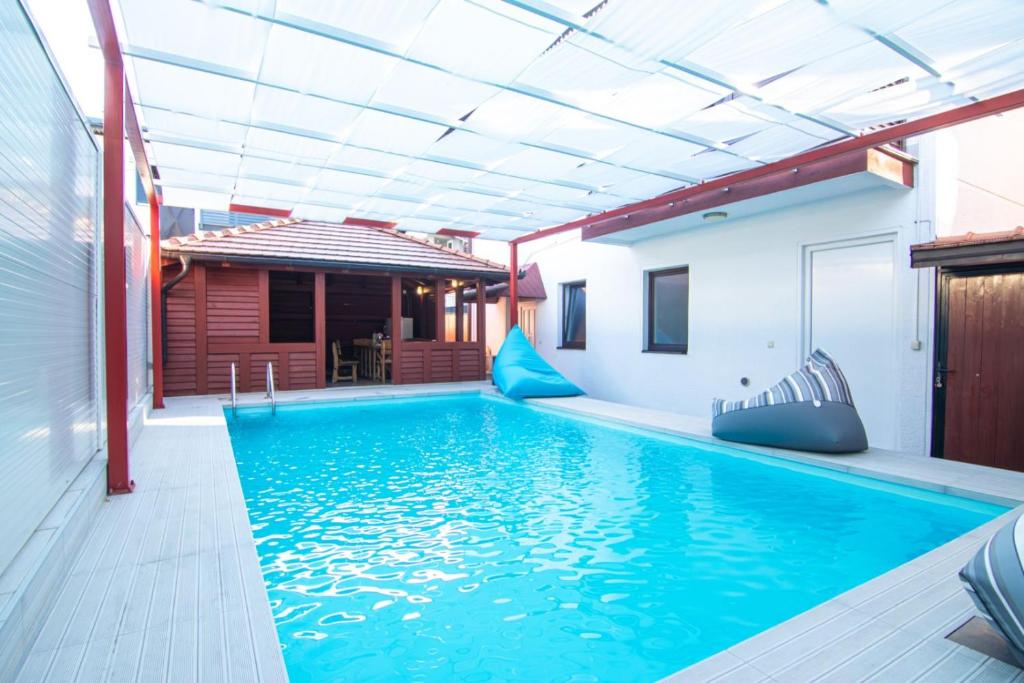 an indoor swimming pool with blue water in a house at Holiday Home Ajna in Bihać