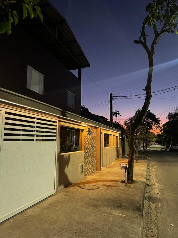 a house with a white garage door on a street at Shiva Hostel in Rio das Ostras