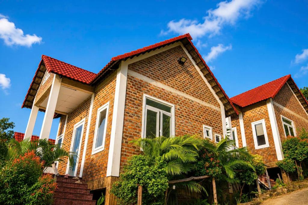 a brick house with a red roof at Bungalow Gió Hát in Phú Quốc