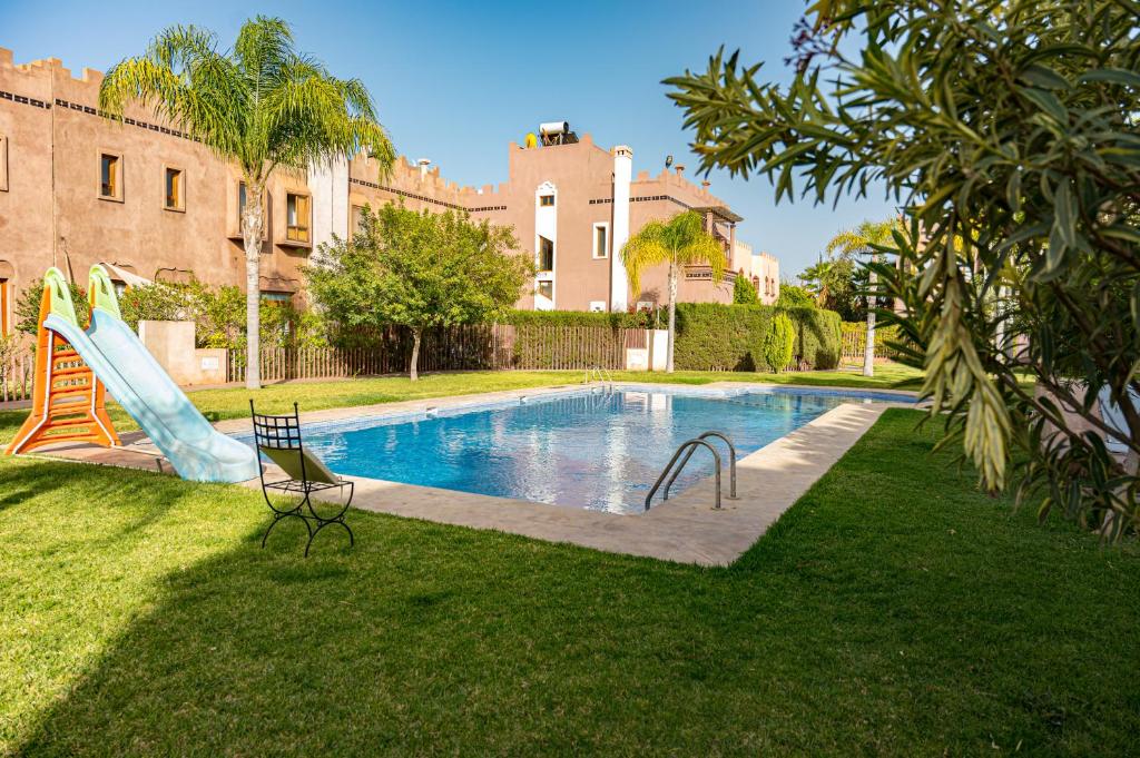 a swimming pool in a yard with a slide at Riad Kenza in Marrakesh