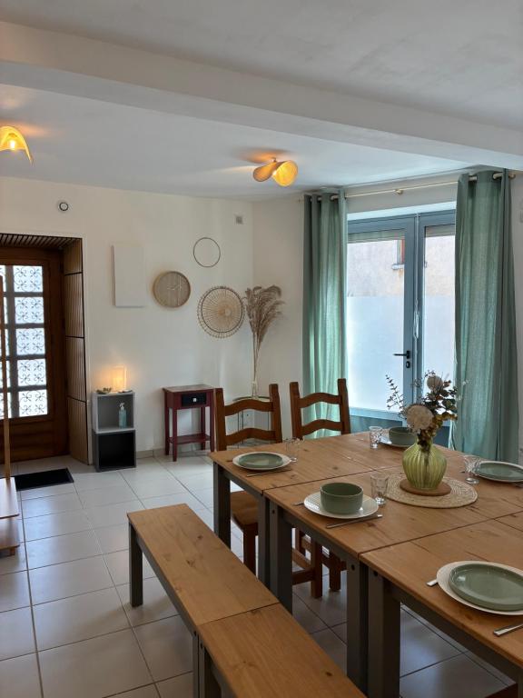 a dining room with a wooden table and chairs at Le 36 du prieuré in Arbois