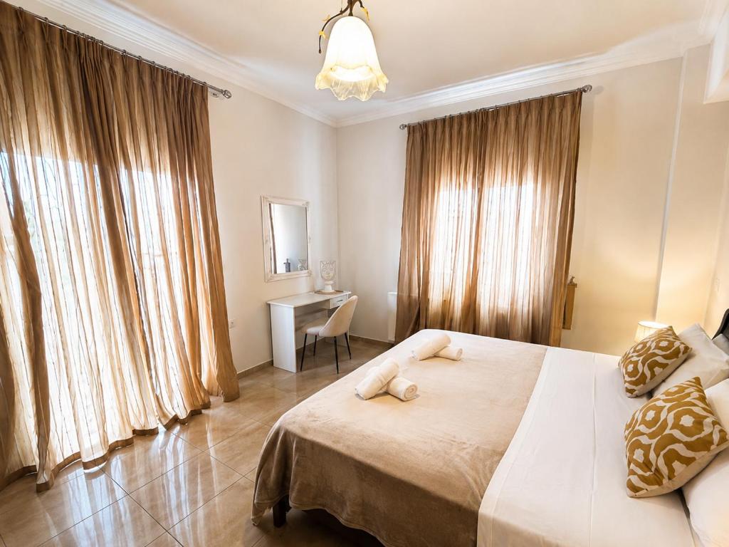 a bedroom with a large bed and a desk at Hermes Casa Hersonissos in Hersonissos