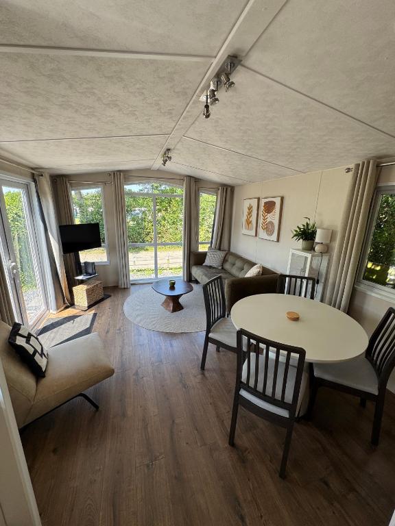 a living room with a table and chairs and a couch at Beach Chalet Sunny Dunes in Petten