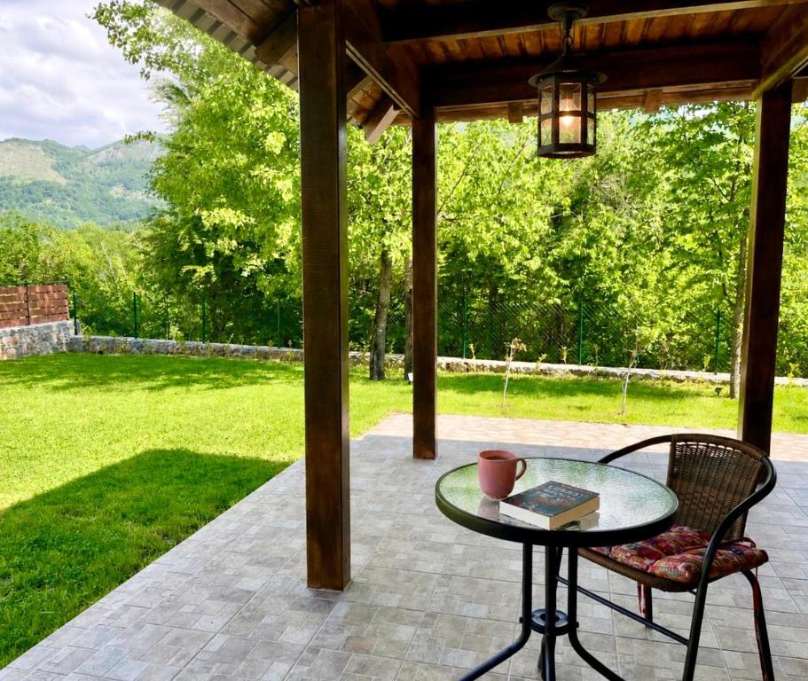 a patio with a table and a chair and a lamp at Holiday house Flores near Kolasin in Kolašin