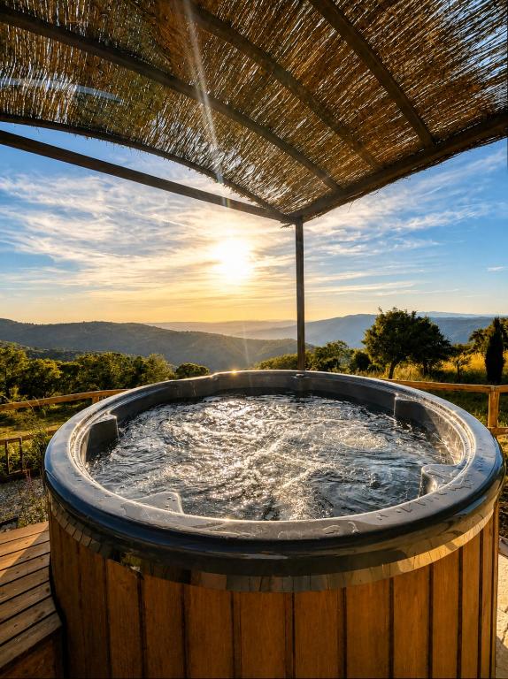 a hot tub on a deck with the sunset in the background at Relais Tosca in Cortona