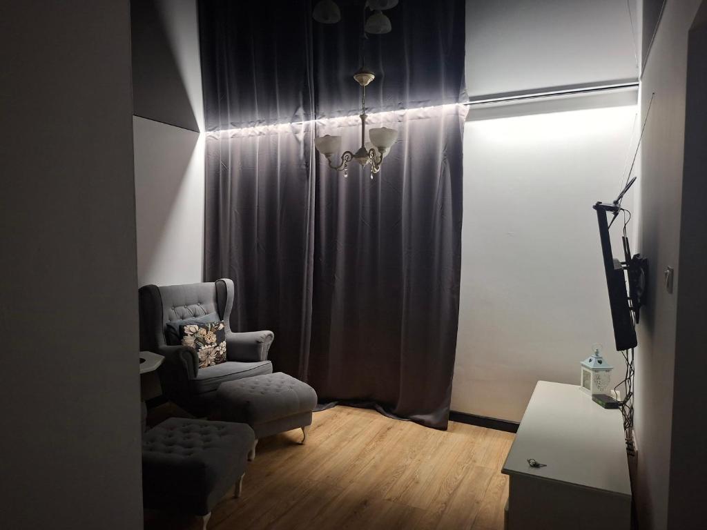 a living room with a chair and a curtain at Łokietka in Inowrocław