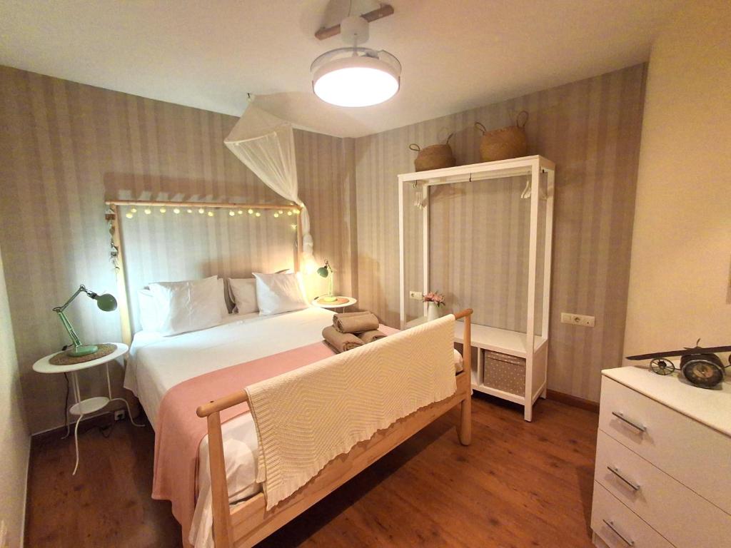 a bedroom with a bed with a dresser and a mirror at Logrocity Corazon de Logroño PARKING PRIVADO GRATIS in Logroño
