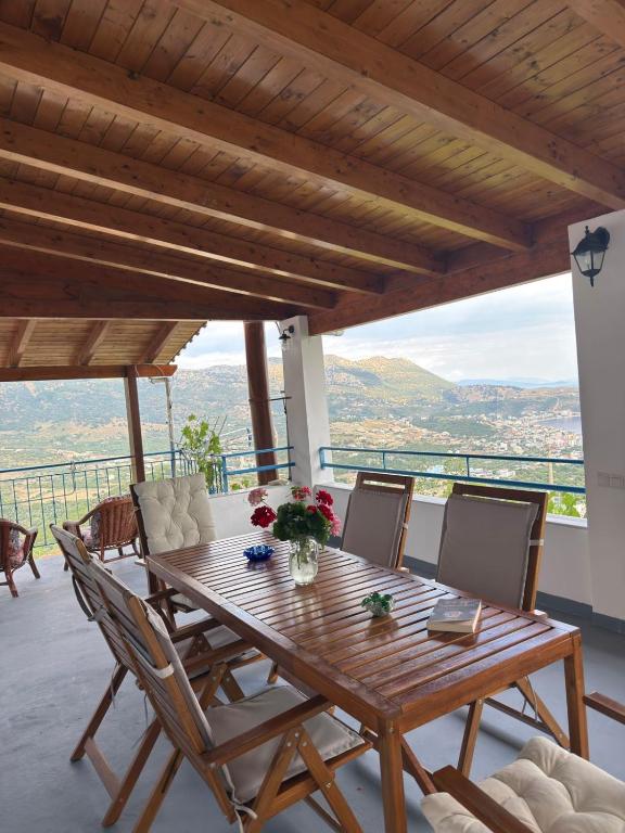 a wooden table and chairs on a balcony with a view at M & A Ionian Balcony in Himare
