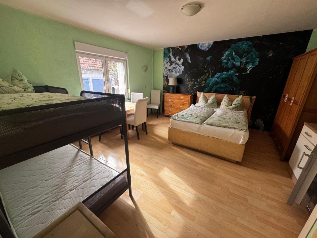 a bedroom with two beds and a table and a painting at Bauernhof Privatzimmer Frei WiFi Gemeinschaftsbad in Hausbreitenbach