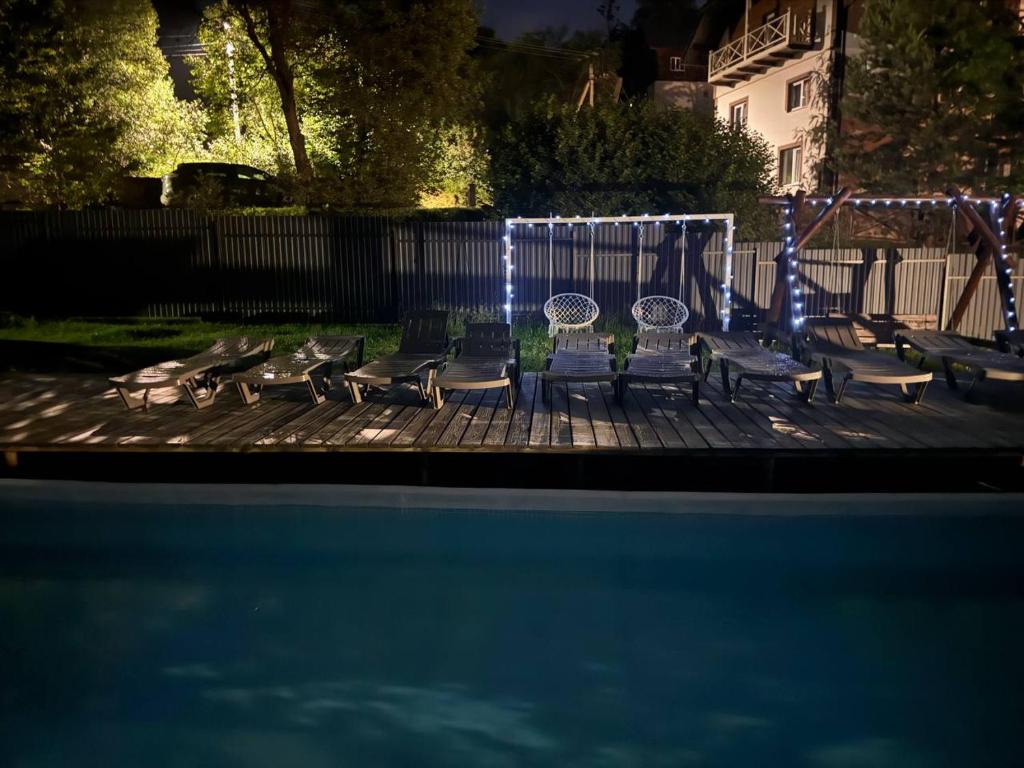 a group of chairs sitting on a deck next to a pool at Trostjn house in Slavske