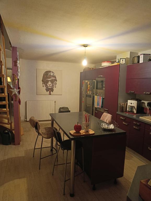a kitchen with a table and chairs in a room at Appartement 90 m2 in Vic-sur-Seille