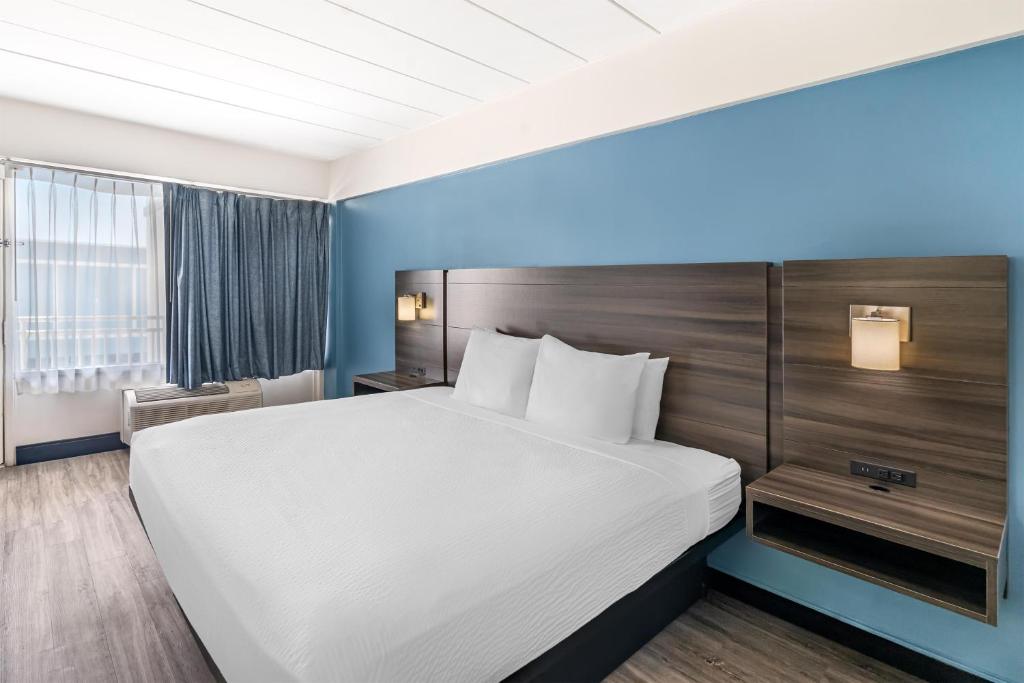 a hotel room with a large bed and a window at SureStay Hotel by Best Western Virginia Beach Royal Clipper in Virginia Beach