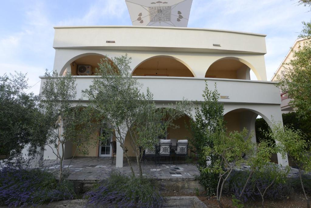 an external view of a building with chairs in the courtyard at Apartments REM-PIFRA in Novalja