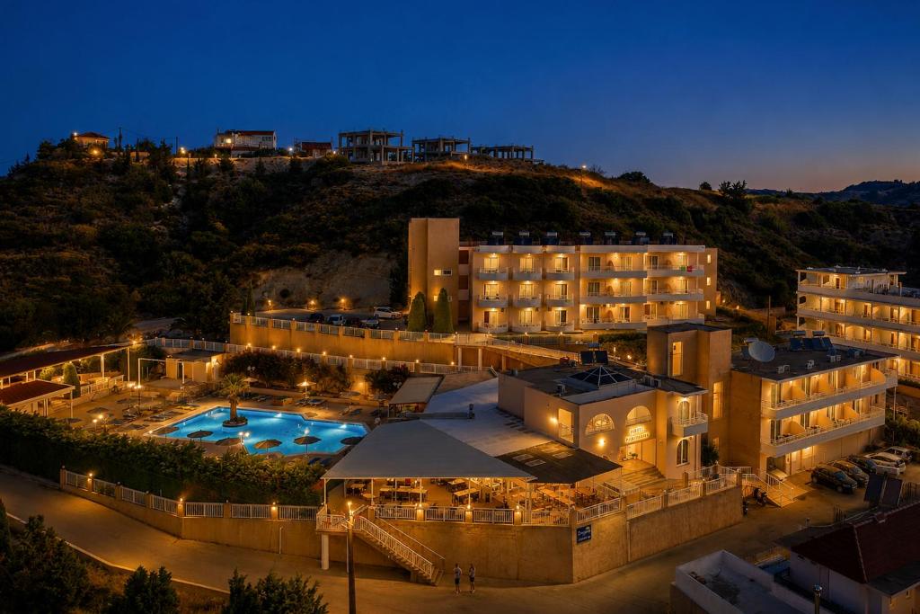 a view of a hotel with a pool at night at Diagoras Hotel All Inclusive in Faliraki