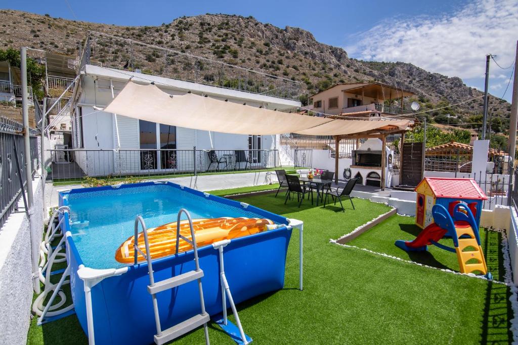 a backyard with a pool and a slide at Ξενώνας της Αγάπης in Salamina