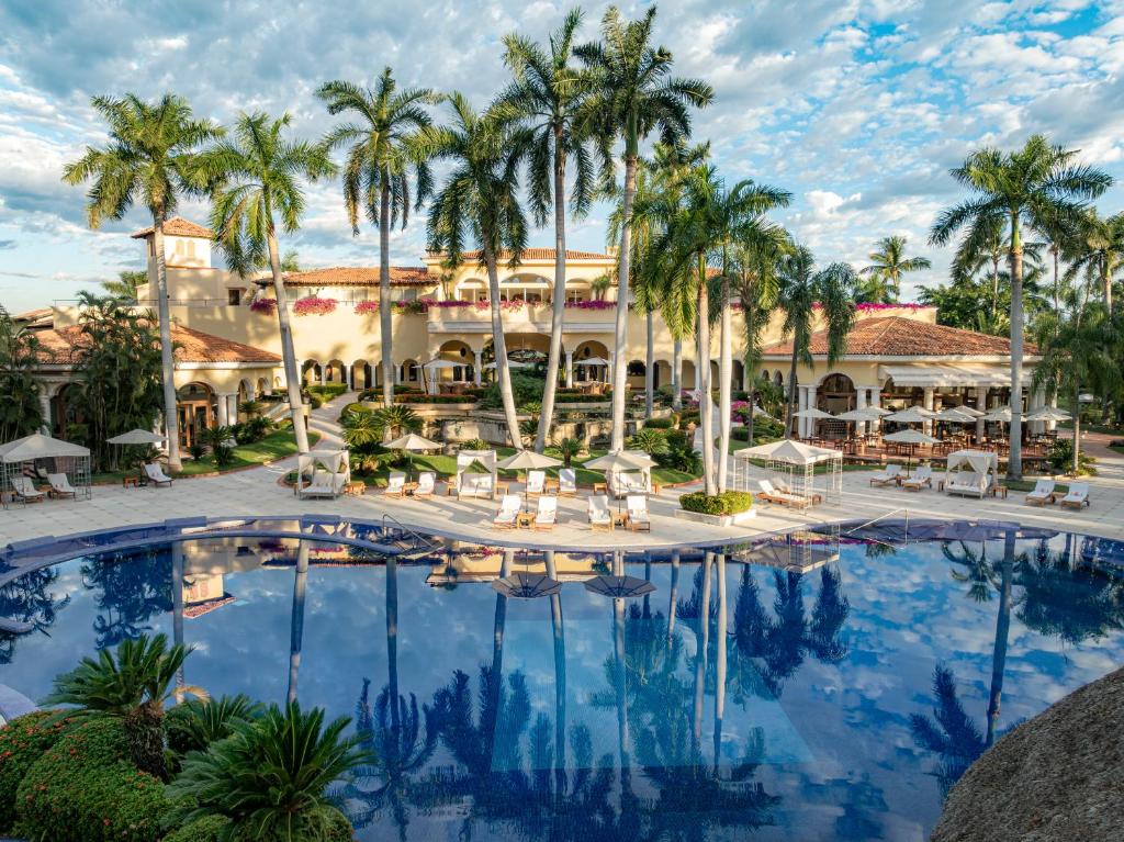 an image of a resort pool with palm trees at Casa Velas Adults Only All Inclusive in Puerto Vallarta