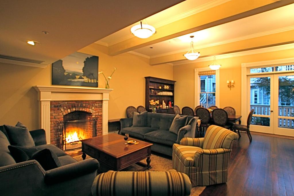 a living room with couches and a fireplace at The Gables Inn Sausalito in Sausalito