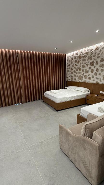 a large room with two beds and a couch at ALAR Rooms in Dhërmi