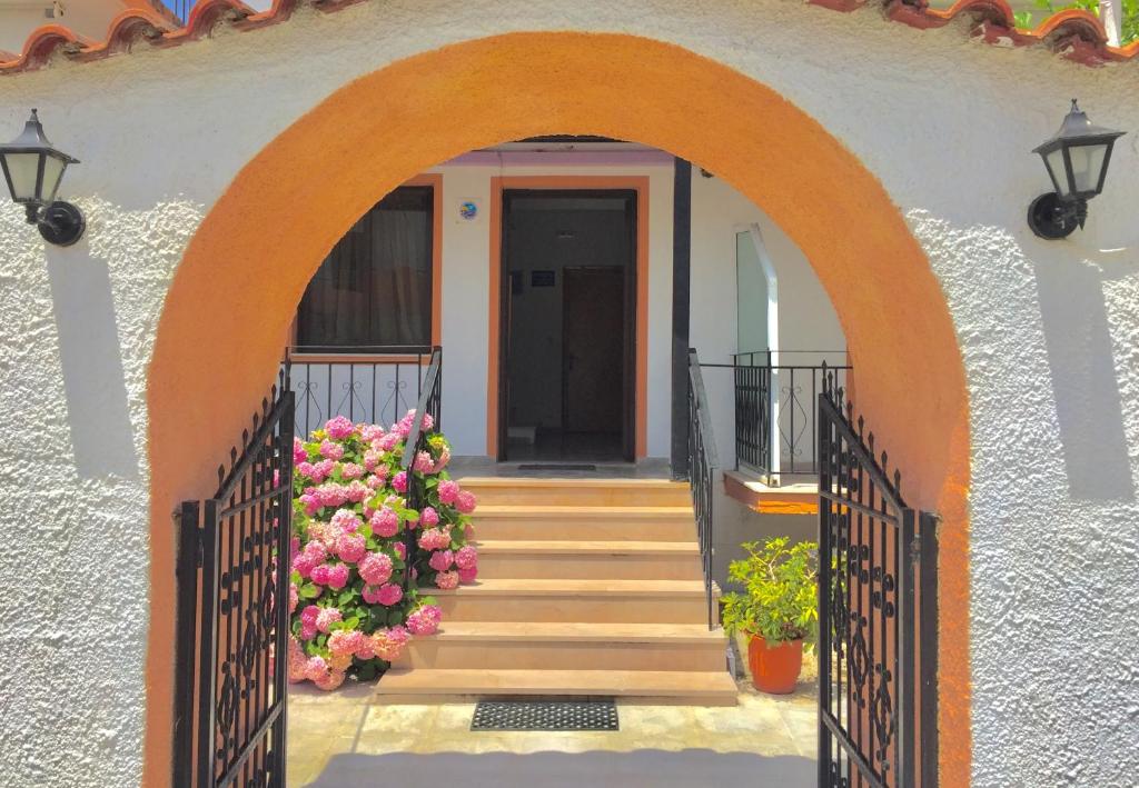 an entrance to a house with an orange gate and flowers at Villa Xenia in Ammoudia