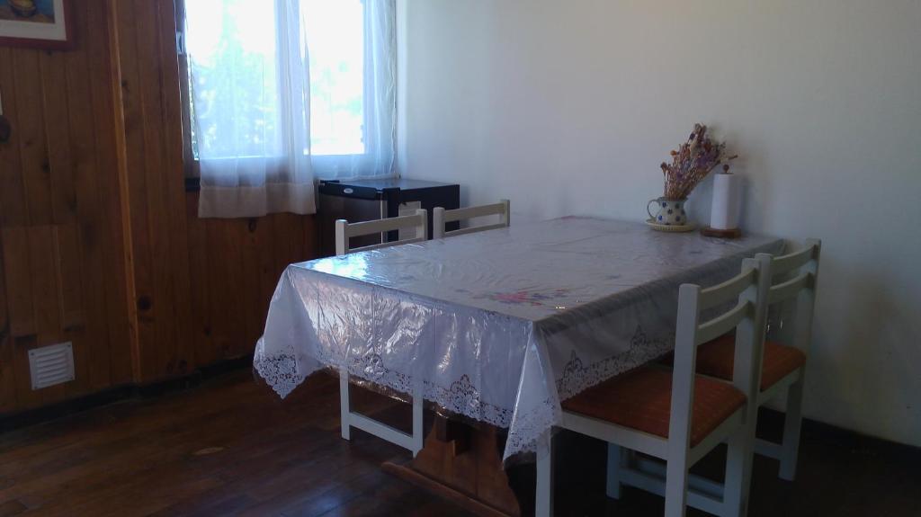 mesa de comedor con mesa blanca y sillas en Departamento Tacuarí en San Carlos de Bariloche
