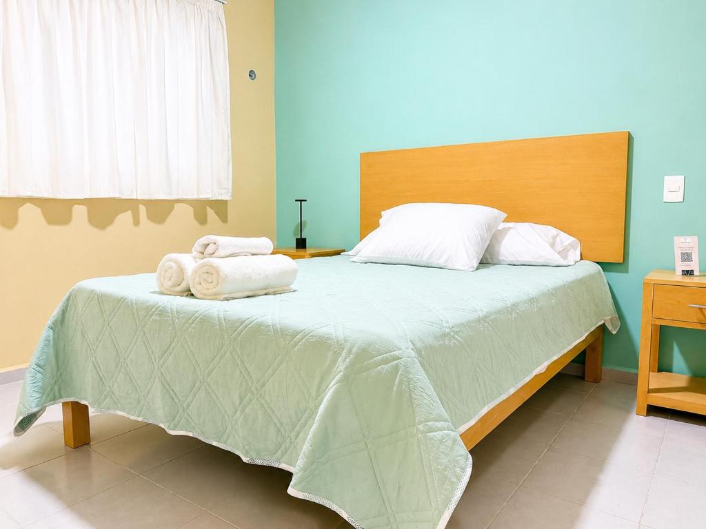 a bedroom with a bed with towels on it at Palma 11 Boutique House Downtown Cancun in Cancún