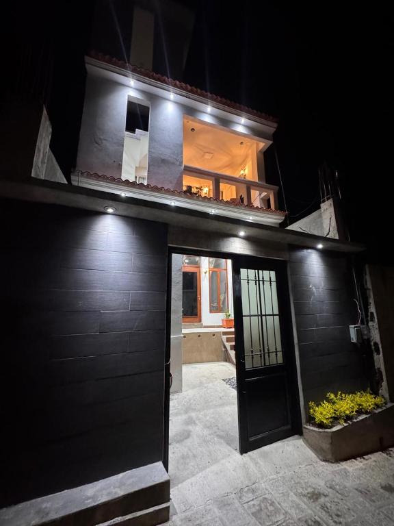 a black building with a door and a balcony at Apartamento REFUGIO DEL LAGO in San Pedro La Laguna