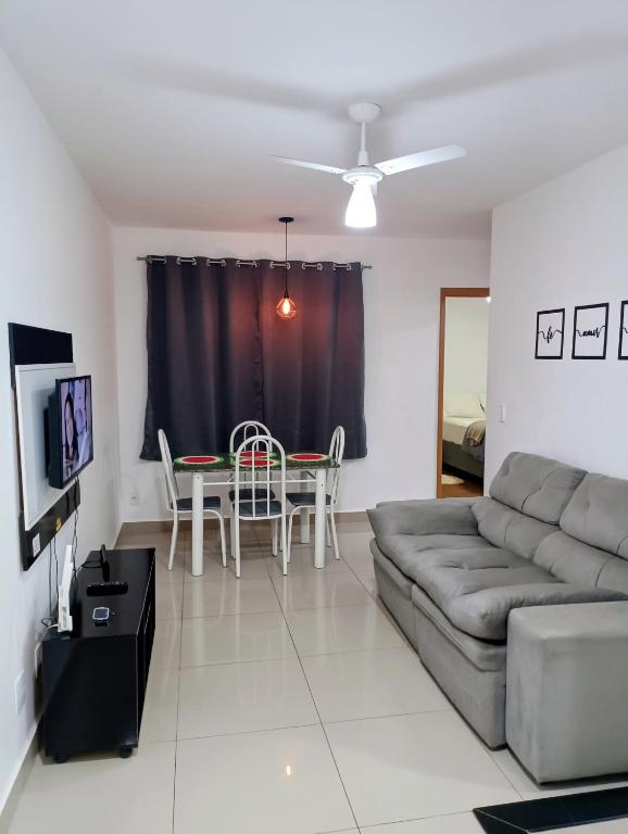 a living room with a couch and a table at Apartamento 5 minutos do parque de exposições in Maringá