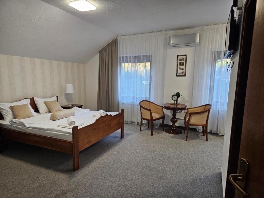 a bedroom with a bed and a table and chairs at Sobe - Rooms Drvorez in Banja Luka