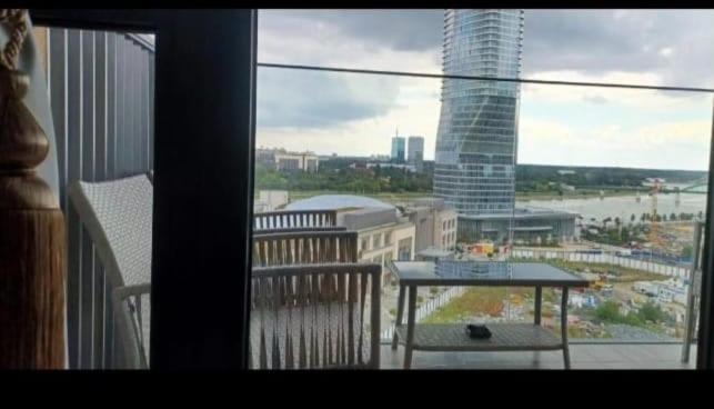 a balcony with a table and a view of a city at Belgrade Waterfront Sole in Sajmište