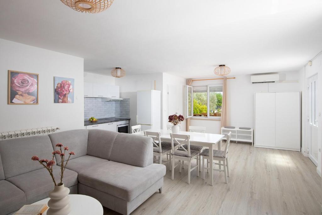 a white living room with a couch and a table at Pula Istria Apartments in Pula