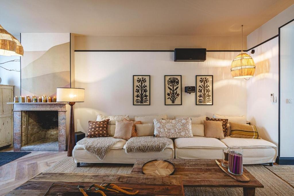 a living room with a white couch and a table at La Maison dAmbre-Jacuzzi-Sauna-Clim-4chambres in Saumur