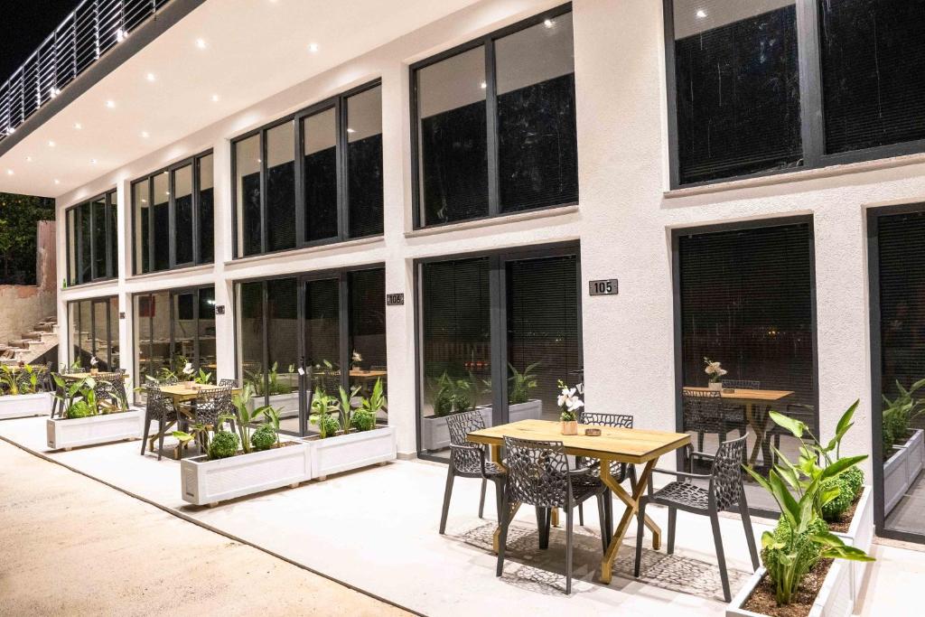 a patio with tables and chairs in front of a building at Hotel&Apartaments -Villa Hasani 24 in Sarandë