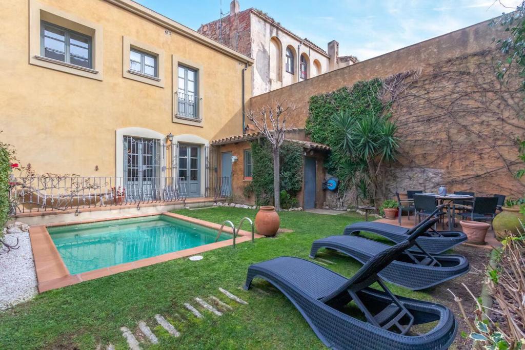 a backyard with a swimming pool and a house at Centro Palafrugell: Casa con Piscina y Solárium in Palafrugell