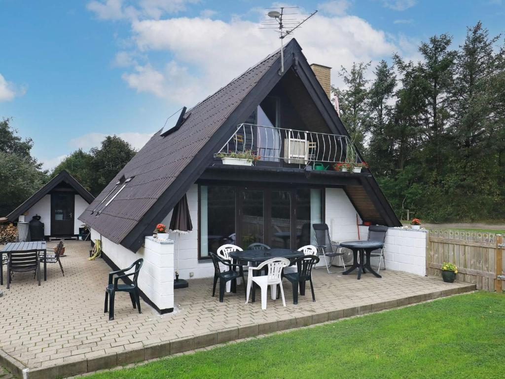 a house with a roof with tables and chairs at 6 person holiday home in Thyholm-By Traum in Thyholm