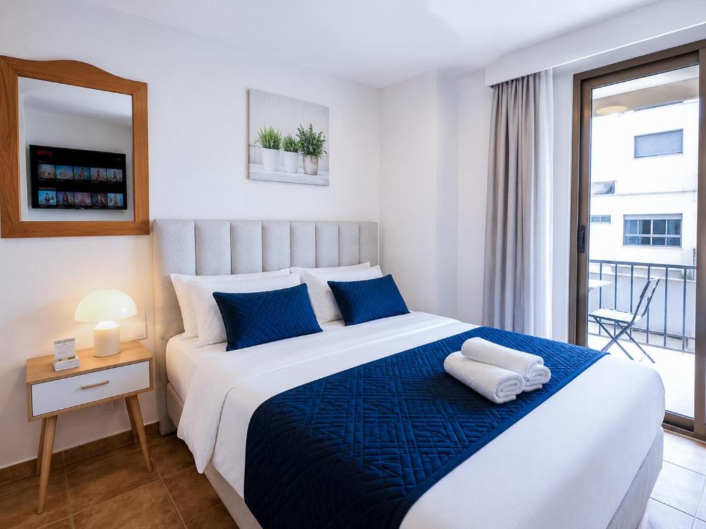 a bedroom with a large bed with blue pillows at Sun Serramar Boutique Hostal in Benalmádena