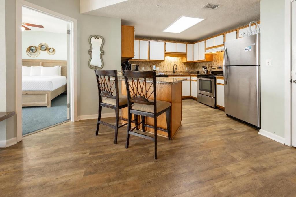 a kitchen with two chairs and a kitchen with a refrigerator at Phoenix X 304 in Orange Beach