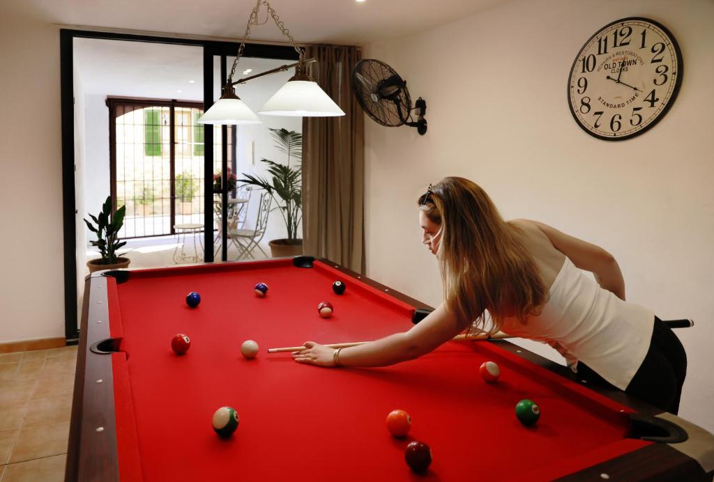 a woman playing pool on a red pool table at Can Calco old town in Alcudia