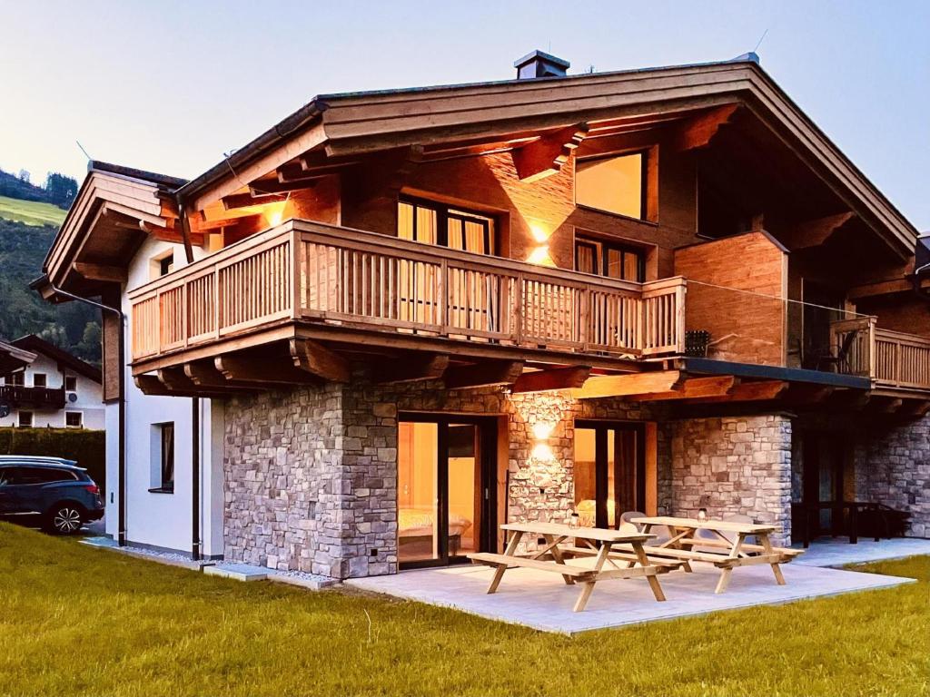 a house with a deck and a picnic table at FIIF Pinzgau in Wald im Pinzgau